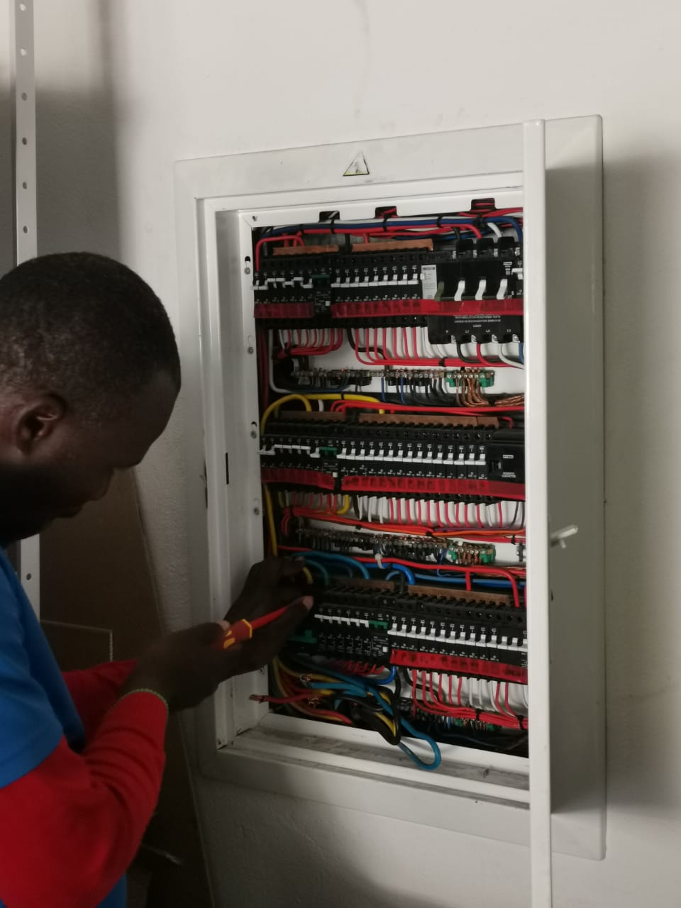 worker wiring electrical distribution box