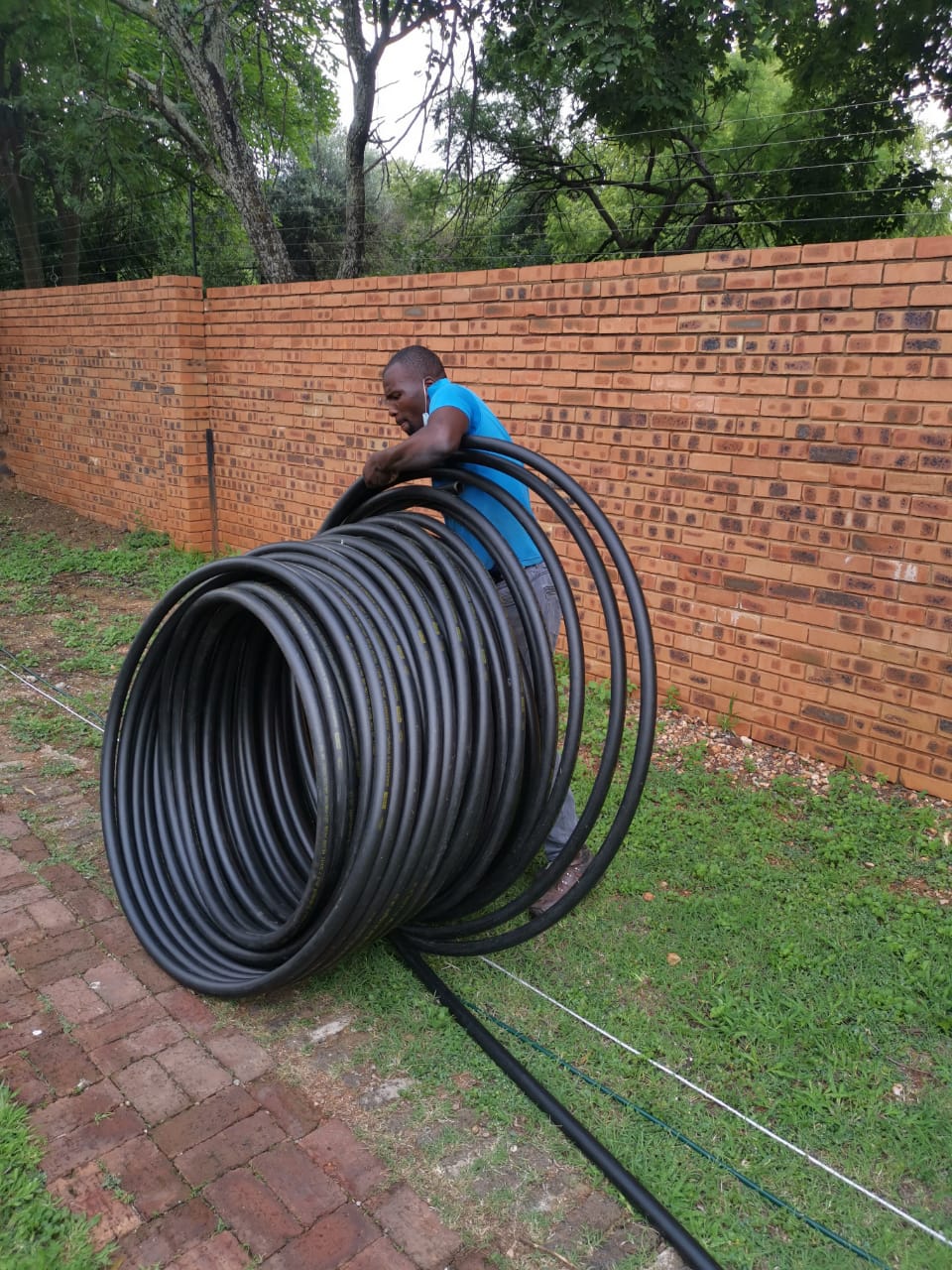 worker with a roll of underground tubing