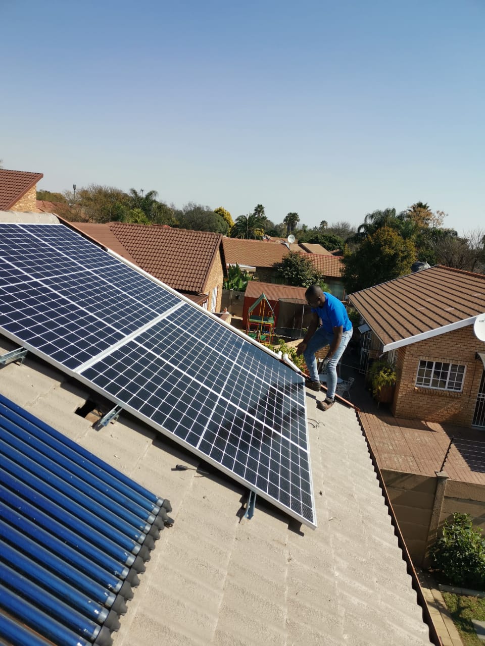 worker on roof with solar panels